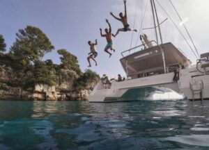 kids jumping off the back of sailing catamaran nia out of miami, florida during catamaran lessons