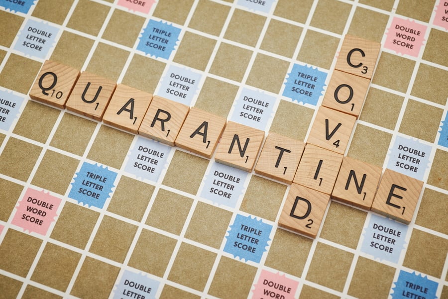 covid and quarantine spelled out on a scrabble board