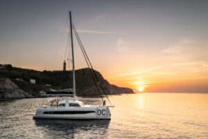 profile view of a catana ocean class 50 anchored at sunset in calm waters