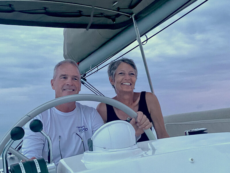 capt dave wiley yacht broker at helm of his 2023 bali 4.2 the tamboo with wife camille